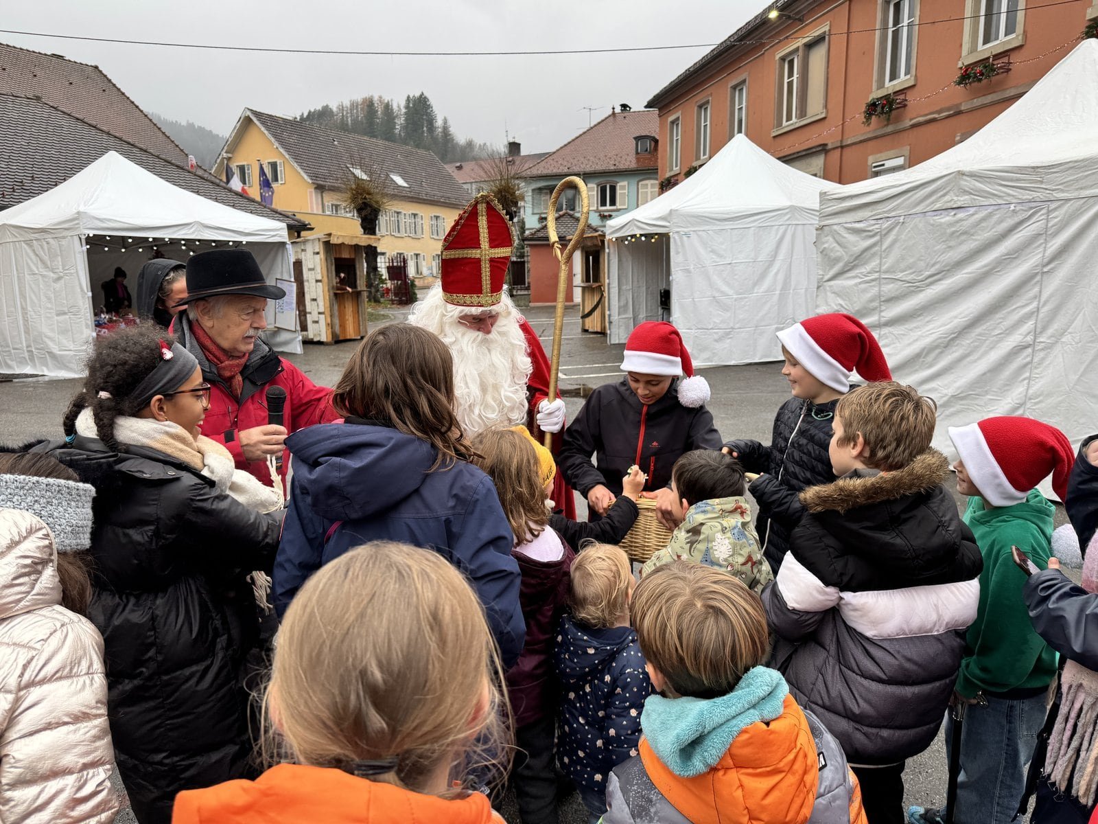 Saint Nicolas entouré d’enfants sur la place du village