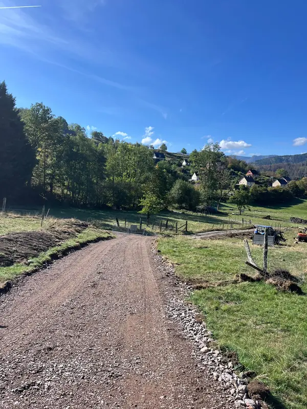 Chemin empierré tout neuf descendant à travers les prés